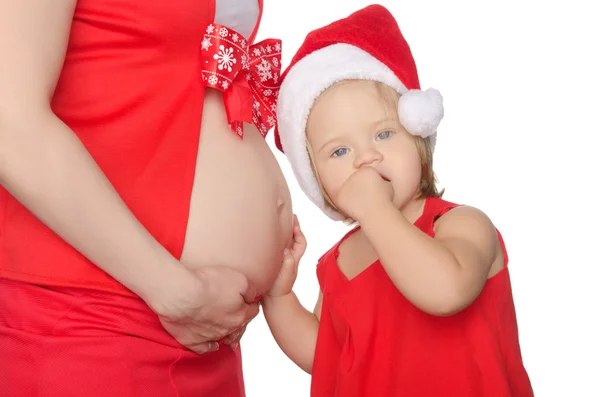 Child listening to belly of pregnant woman at Christmas — Stock Photo, Image