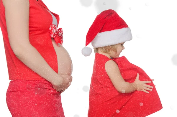 Ventre de femme enceinte et enfant à Noël, flocons de neige — Photo