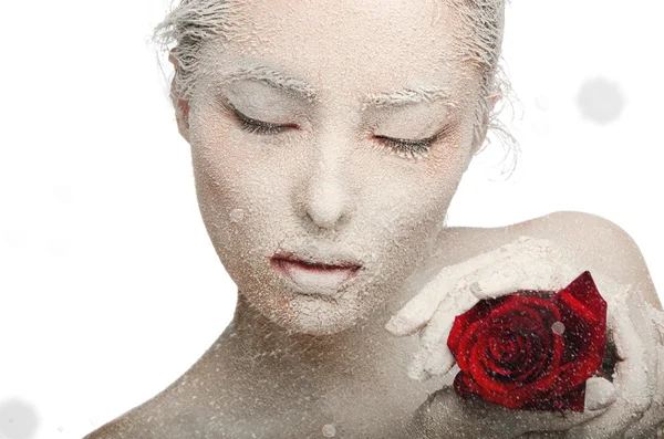 Frozen woman in snow and with rose his hands — Stock Photo, Image