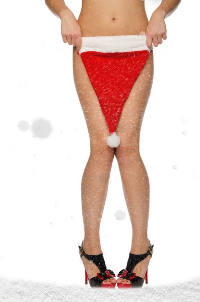 Красивые женские ноги с рождественской шапкой и снегом — стоковое фото