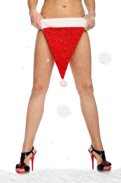 Sexy weibliche Beine mit Weihnachtsmütze und Schnee — Stockfoto