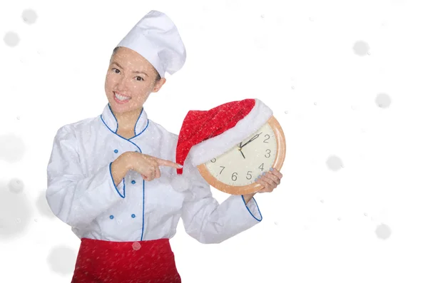 Asian chef points at clock with Christmas hat — Stock Photo, Image