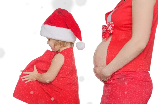 Ventre de femme enceinte et enfant à Noël, flocons de neige — Photo