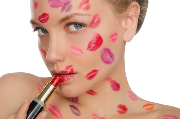 Woman with kisses on face holding lipstick — Stock Photo, Image