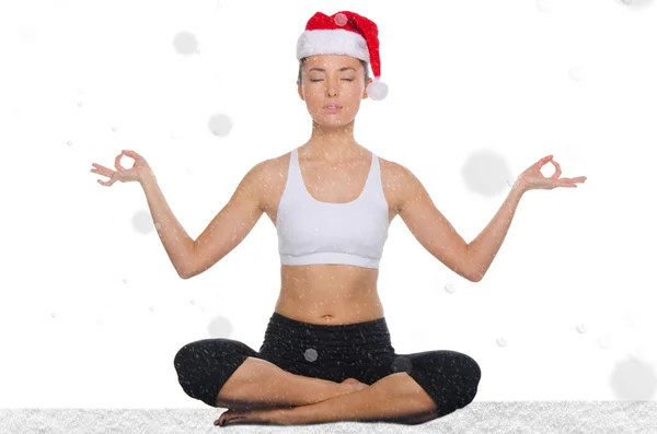 Asiatisk kvinna i jul hatt med snö utövar yoga — Stockfoto