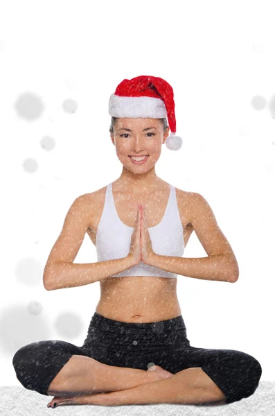 Happy asian in christmas cap with snow practicing yoga — Stock Photo, Image