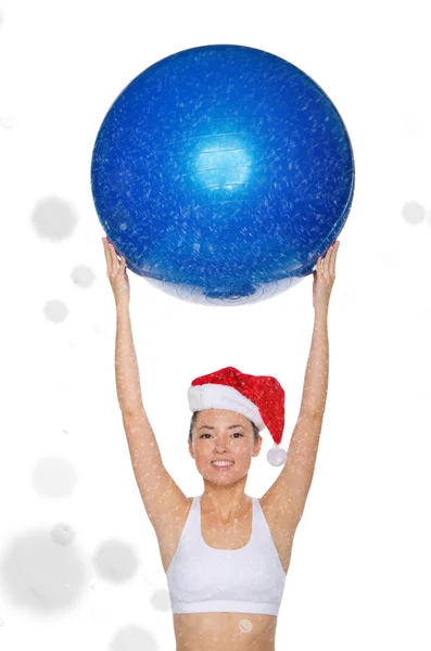 Smiley asiatisk kvinna i Santa mössa rymmer fitball under snö — Stockfoto