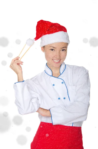 Sourire asiatique chef en tenue de Noël avec baguettes sous la neige — Photo