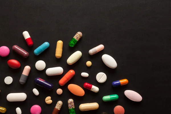 Colorful pills on black — Stock Photo, Image