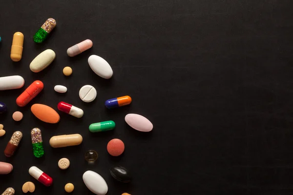 Pillole colorate sul nero — Foto Stock