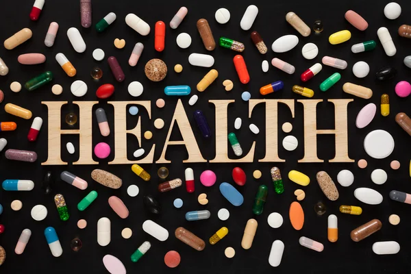 Pílulas coloridas em preto — Fotografia de Stock