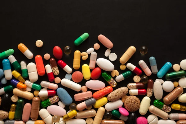 Colorful pills on black — Stock Photo, Image