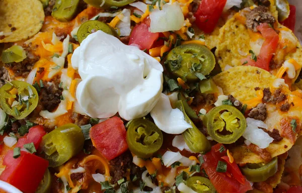 Wyjąć Pudełko Nachos Zwieńczone Wołowiną Jalapenos Pomidorami Cebulą Serem Odrobiną — Zdjęcie stockowe