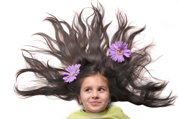 Meisje met gewaaide haren en bloemen — Stockfoto