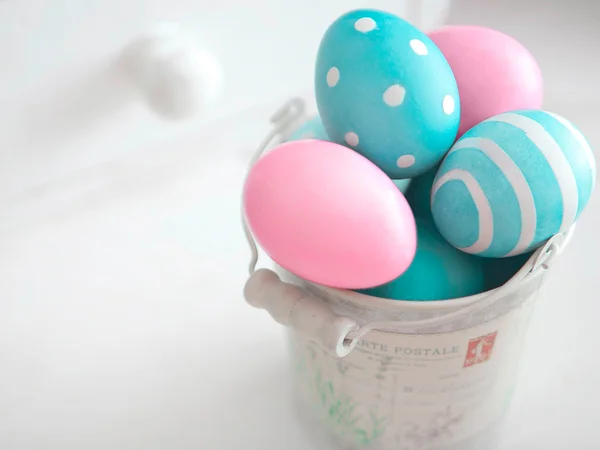 Easter eggs of pastel colors in vintage bucket on light background Stock Image