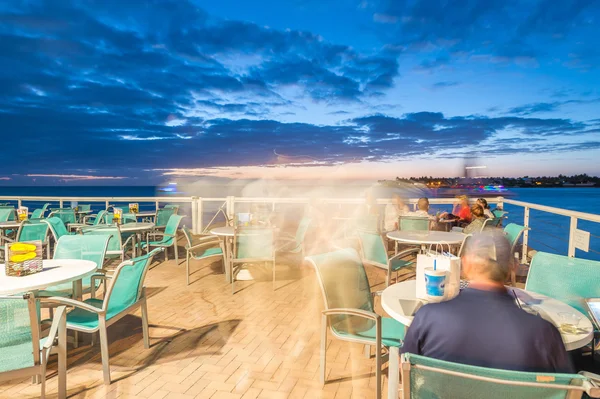 Люди отдыхают в ресторане под открытым небом на берегу моря у моря. — стоковое фото