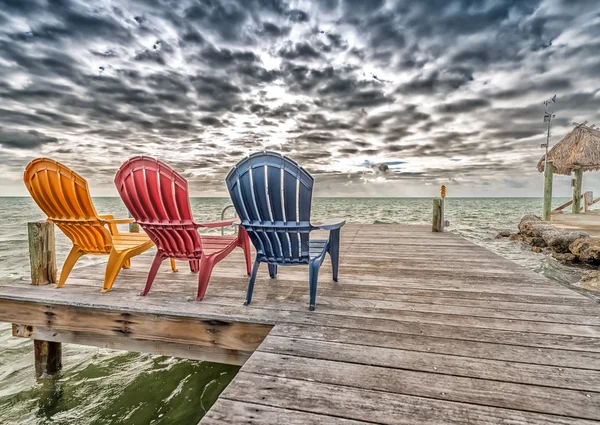 Πολύχρωμα καρέκλες στα σύνορα στον ωκεανό — Φωτογραφία Αρχείου