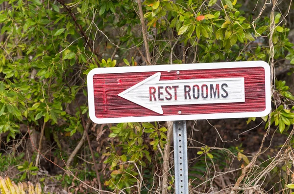 Restrooms sign against green background — Stock Photo, Image