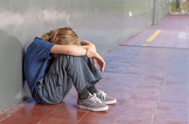 Öğrenci okulda katta oturuyor. Bullying ve yalıtım con