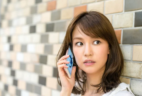 Young Asian woman speaking at phone — Stock Photo, Image