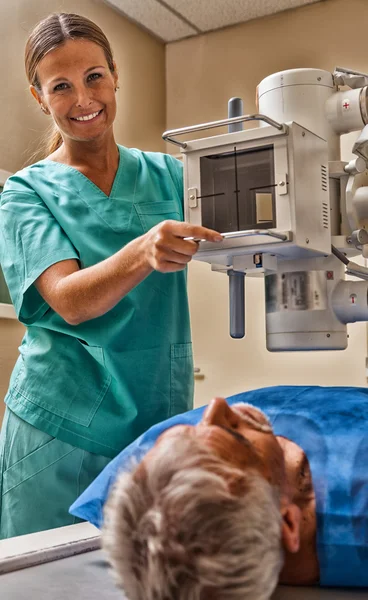 Volwassen mannelijke patiënten ondergaan test op xray machine bijgestaan door — Stockfoto