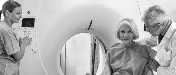 Oude vrouwelijke patiënt ondergaat, mri in ziekenhuis bijgestaan door arts — Stockfoto