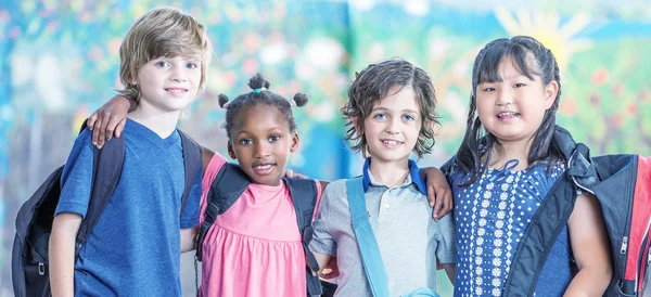 Glückliche multiethnische Klassenkameraden, die sich auf dem Schulhof umarmen, Glück — Stockfoto