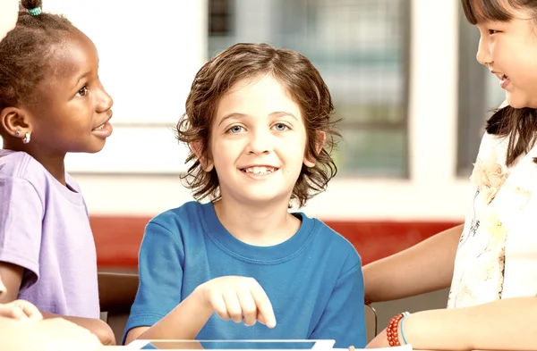 Schoolboy na escola em sala de aula multi corrida — Fotografia de Stock