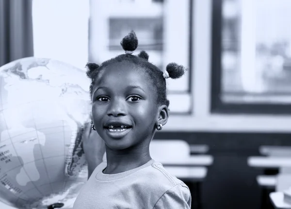 Menina africana na escola com globo terrestre no fundo, geografia — Fotografia de Stock