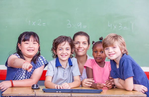 Mitschüler und Lehrer lächeln gemeinsam im Klassenzimmer — Stockfoto