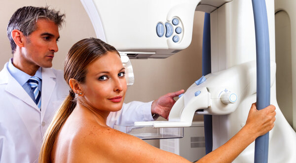 Doctor Assisting Patient Undergoing Mammogram