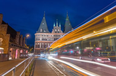 Lubeck, Almanya. Ortaçağ Holstentor kapısı araba ile gece ve 