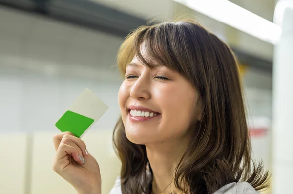 Kobieta posiadająca kartę kredytową i uśmiechnięta — Zdjęcie stockowe