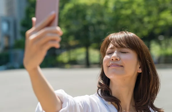 Mujer joven haciendo selfie con smartphone — Foto de Stock