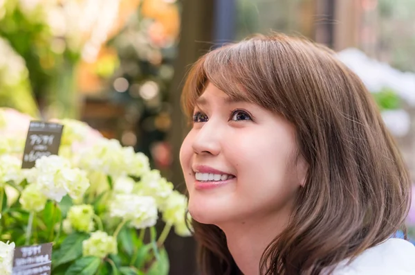 Woman enjoying fragrance of beautiful flowers — Stock Photo, Image