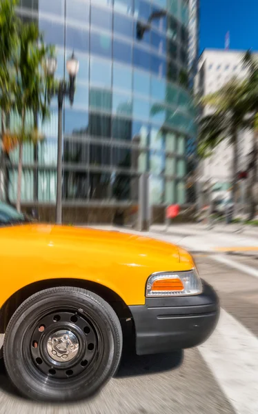 Жёлтое такси ускоряется по улицам города — стоковое фото