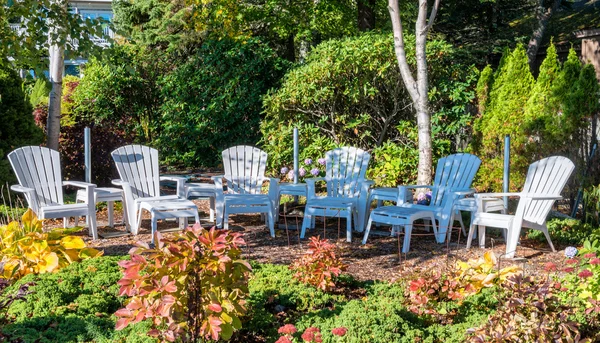 Białe plastikowe krzesła w ogrodzie — Zdjęcie stockowe