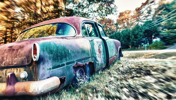 Verlassenes Auto rostet auf Feld — Stockfoto