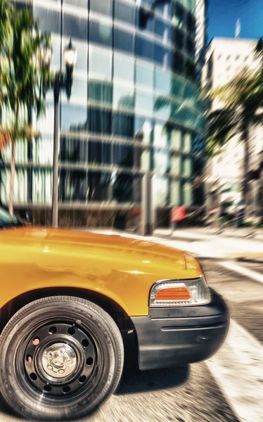 Táxi amarelo acelerando ao longo das ruas da cidade — Fotografia de Stock