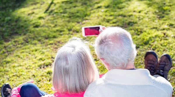 Gepensioneerde paar maken een selfie in een tuin. Geluk en Unie — Stockfoto