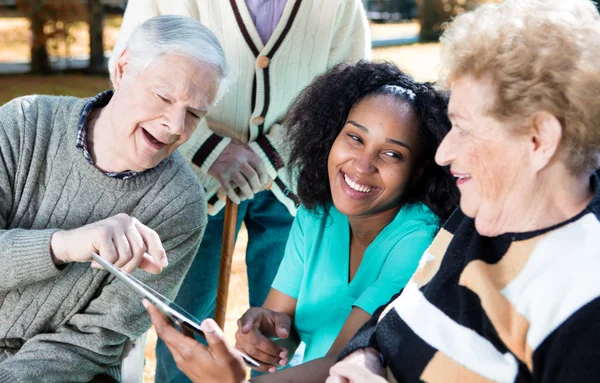 Verpleegkundige gebruik van tablet tot senior mensen uit te leggen — Stockfoto