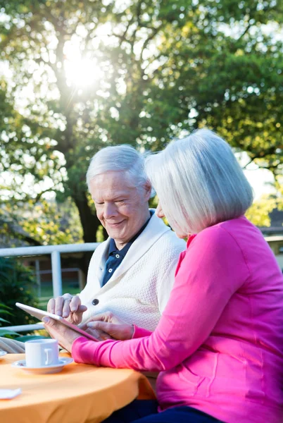 Gelukkige ouderling paar in 70s buiten met technologie-gadget — Stockfoto