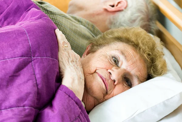 Yaşlı çift yatakta rahatlatıcı — Stok fotoğraf