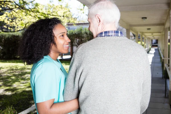 Nurse assisting elder man outdoor