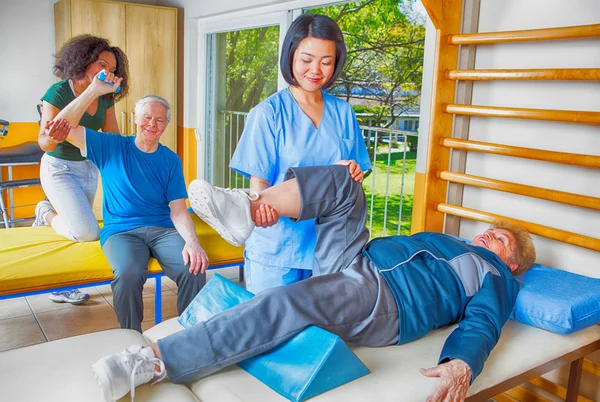 Nurse assisting elder people in a rehab facility gym — Stock Photo, Image