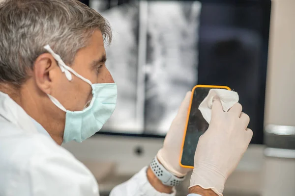 Mannelijke Arts Met Masker Handschoenen Covid Afdeling Schoonmaken Smartphone — Stockfoto