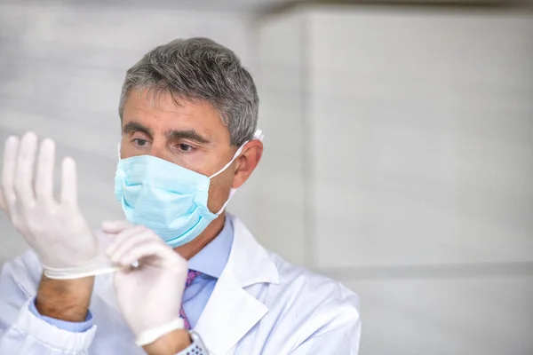 Male doctor wearing mask and gloves in covid-19 department.
