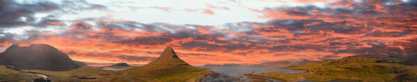Sunset sky colors over Kirkjufell Mountain, panoramic aerial view.