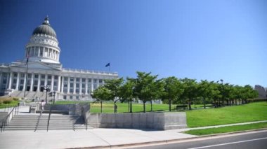 15 Temmuz 2019 'da Salt Lake City' de güzel bir yaz gününde Amerikan ve Utah Eyalet Bayrakları Capitol Binası 'na el sallıyor.