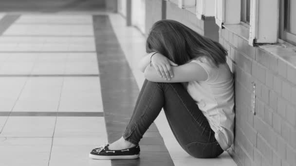 Jeune adolescent asiatique bouleversé assis sur le trottoir du couloir de l'école. Concept d'intimidation. Mouvement lent — Video